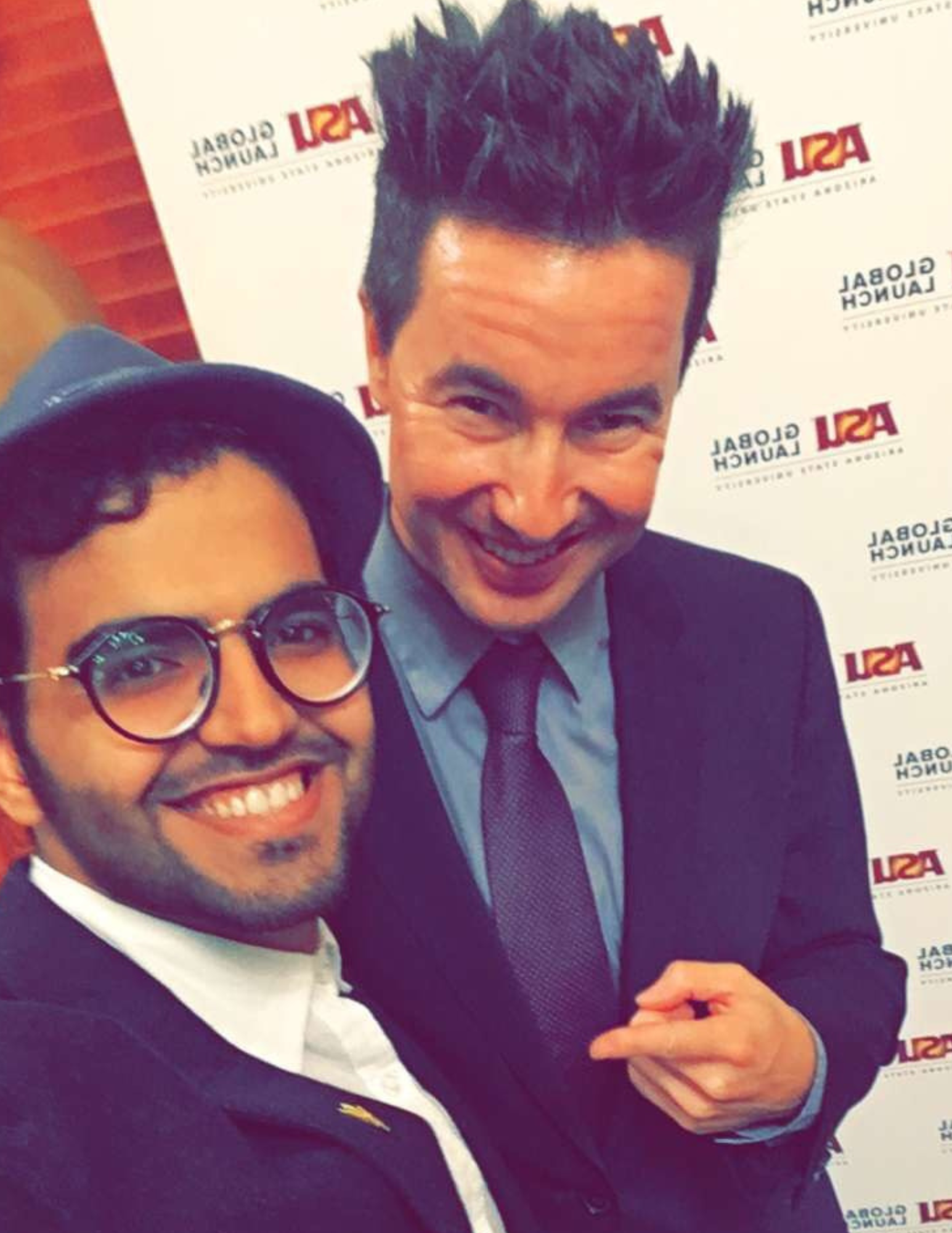 Student poses for a selfie with English teacher at graduation.