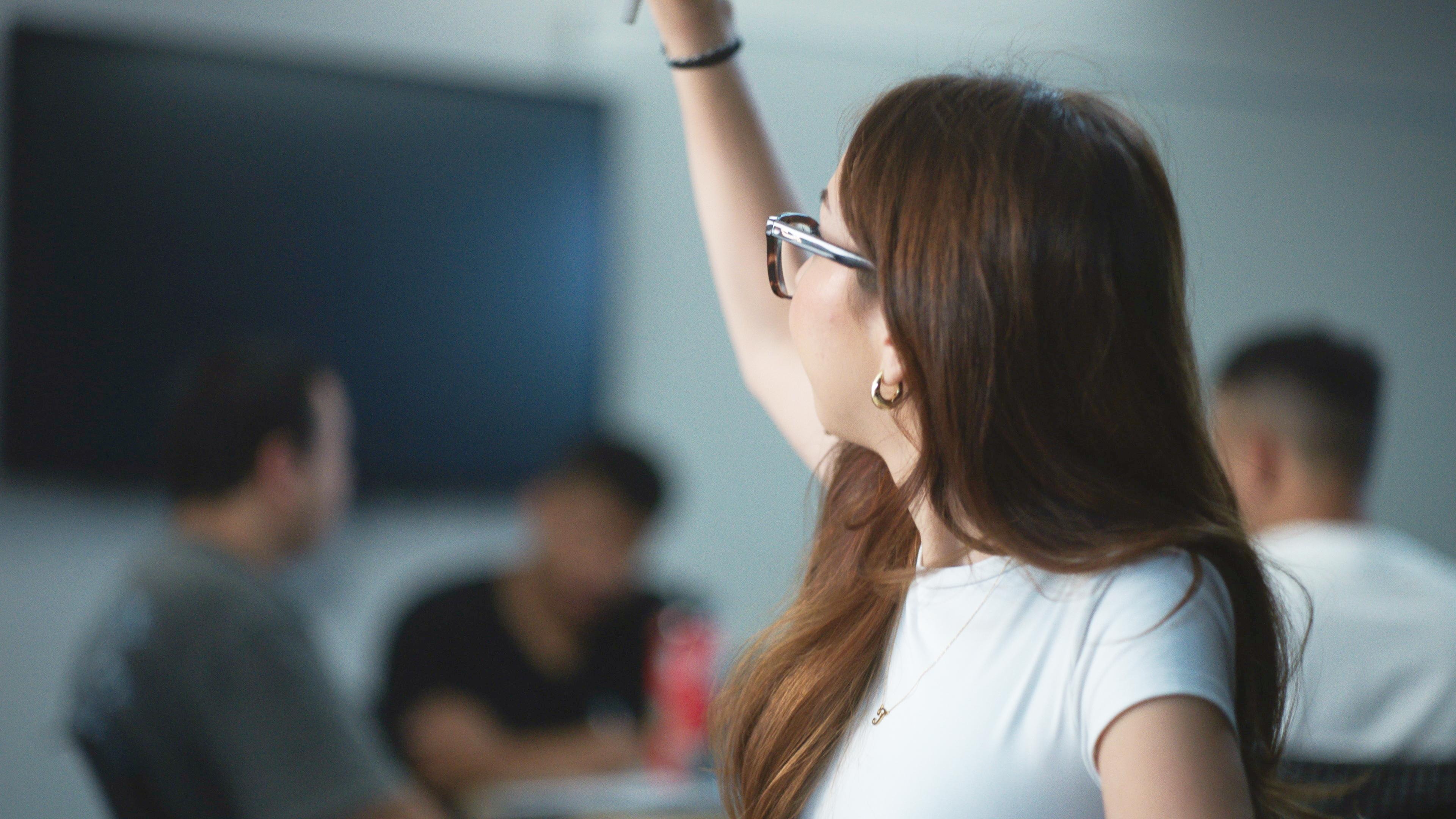 A student raising her hand during class.