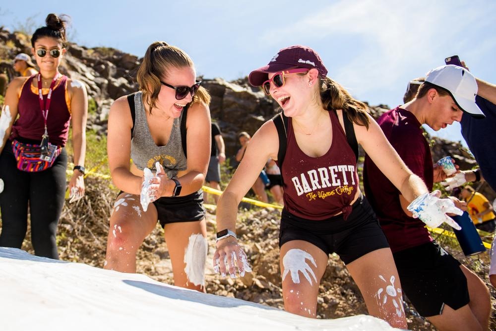 Arizona State University students laughing while whitewashing the "A" on A Mountain.