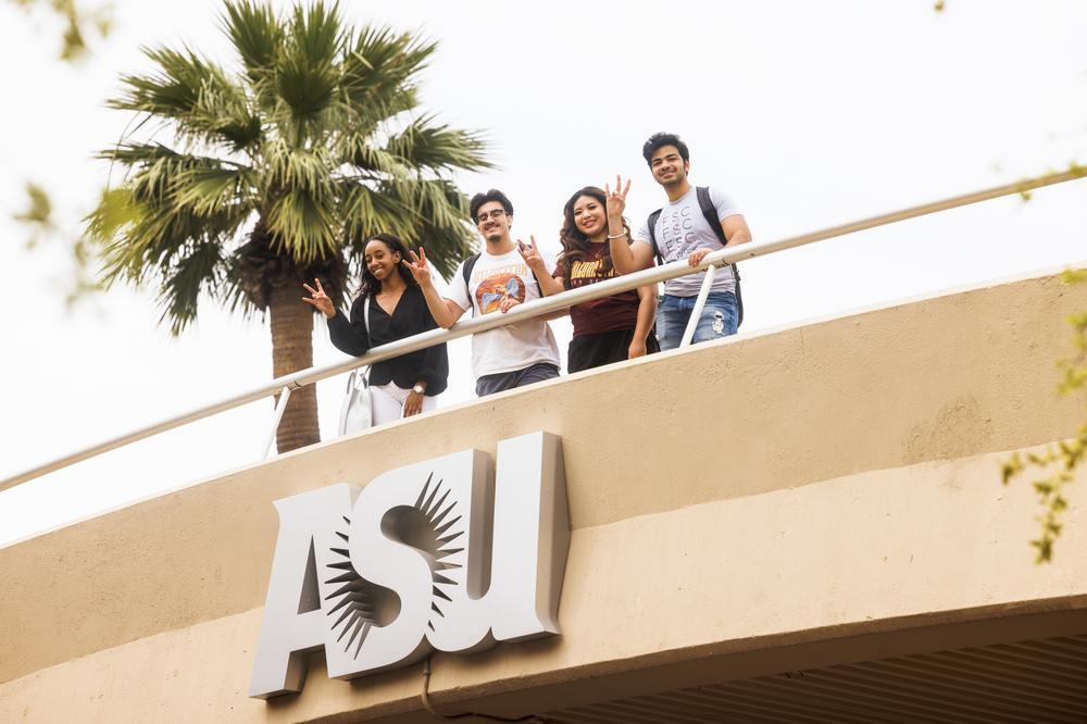 ASU students show their pride on the ASU pedestrian bridge on Tempe campus by making the pitchfork sign