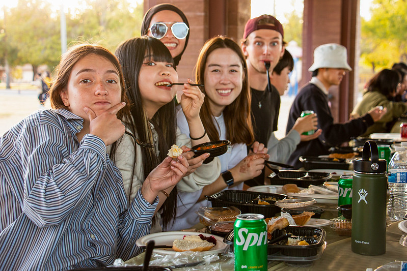 A group of ASU students making silly faces during an outdoor lunch.