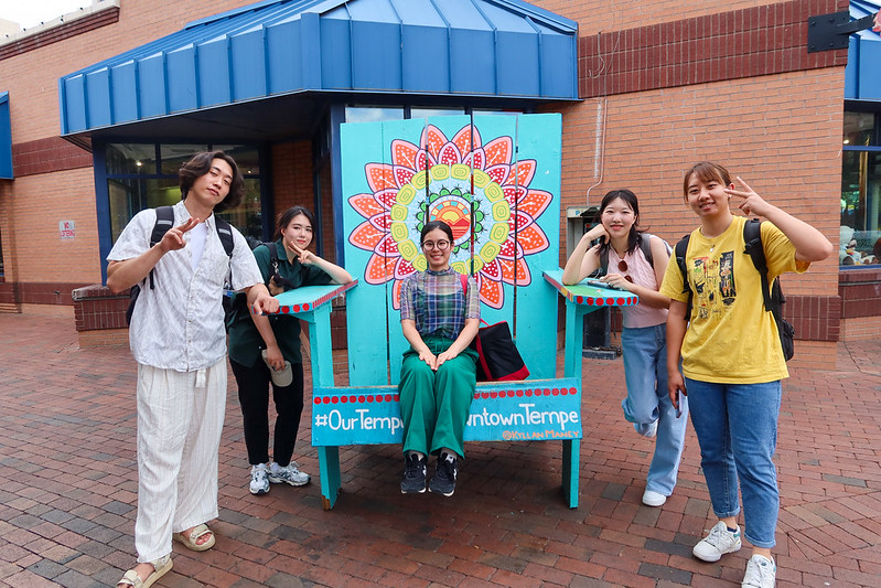 ASU Students posing with a large chair on Mill Avenue during Welcome Week.