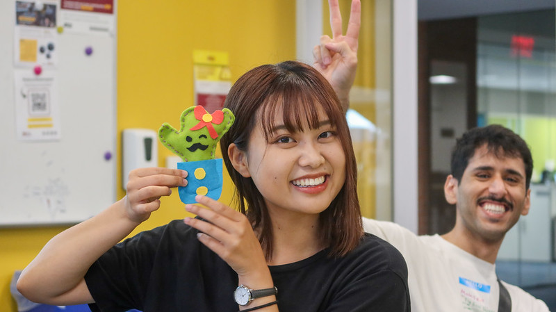 A student proudly displays a felt cactus craft she recently made.