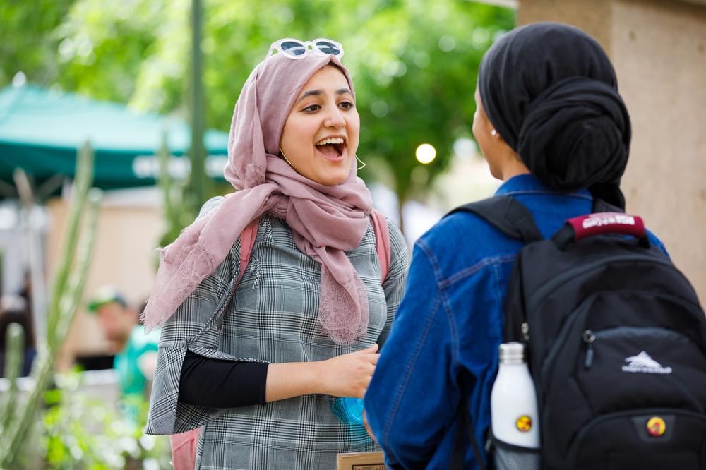 Two ASU students engaging in conversation outside of Tempe campus Memorial Union.