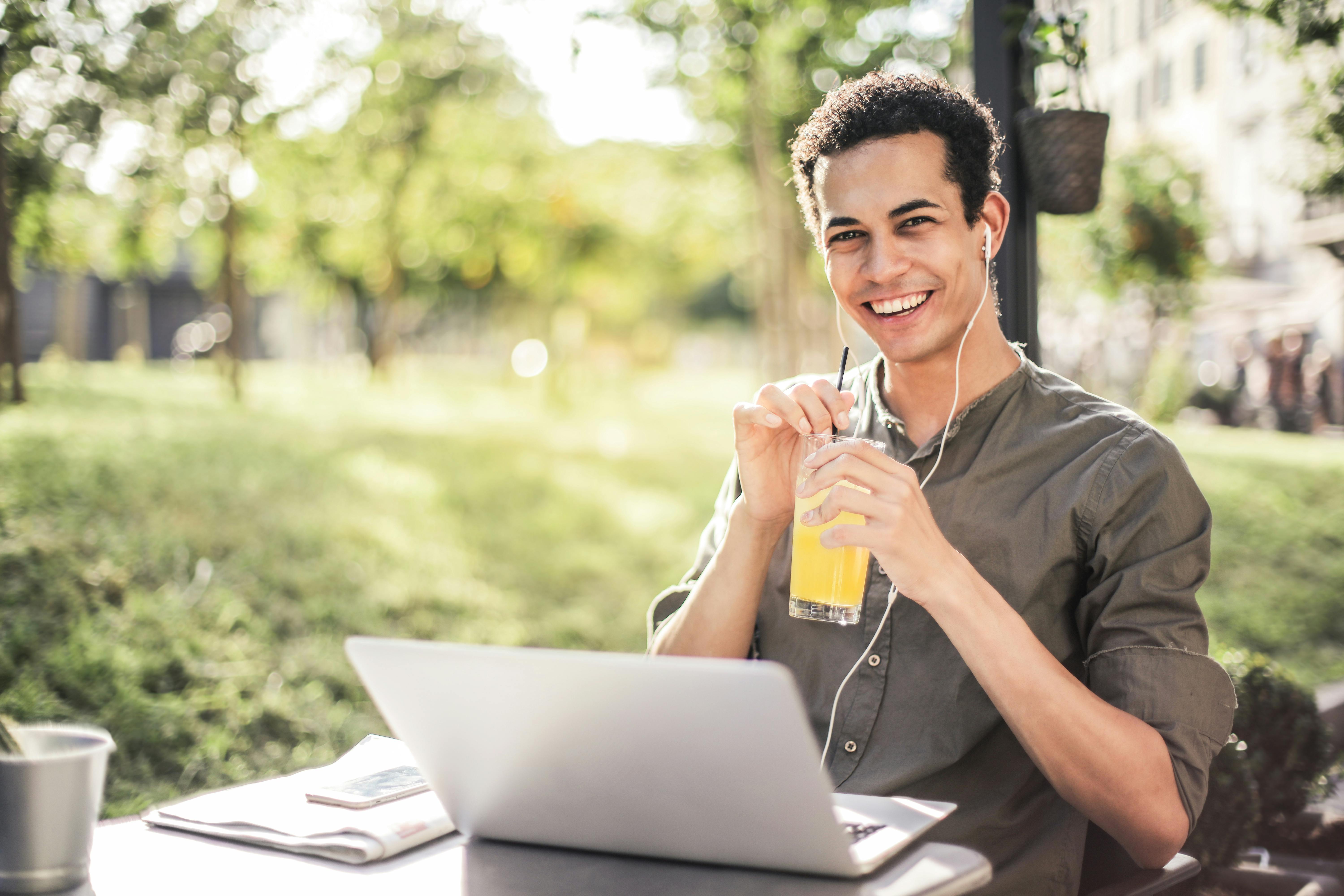 Student listening to music at his laptop outside. Photo by Andrea Piacquadio via Pexels.