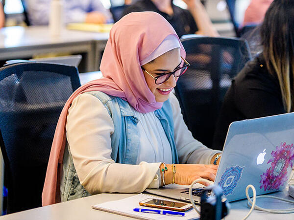 Student at ASU working on a laptop during lecture