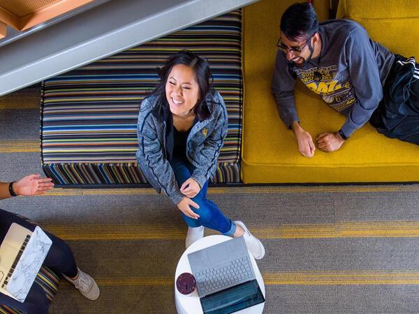 Four ASU students relax in a lounge, happy and talking.