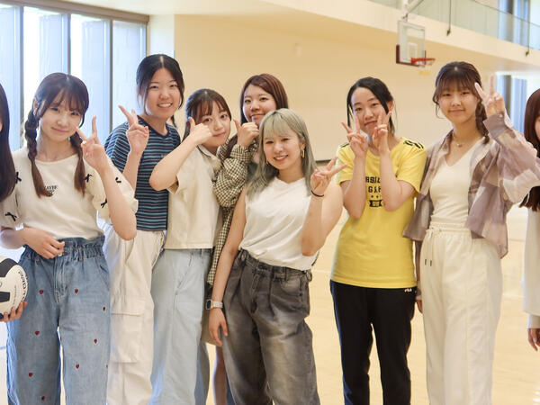 A group of students posing for a photo after playing volleyball.