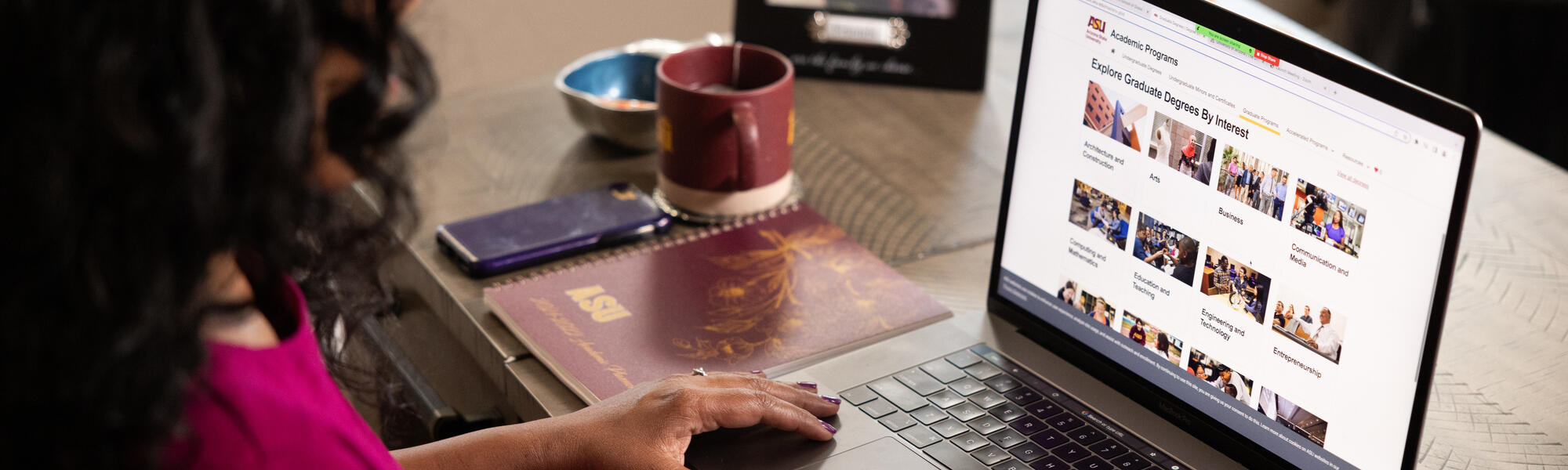 ASU student exploring graduate degree programs on her laptop at home.