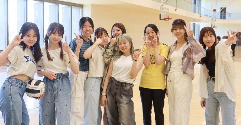 A group of students posing for a photo after playing volleyball.