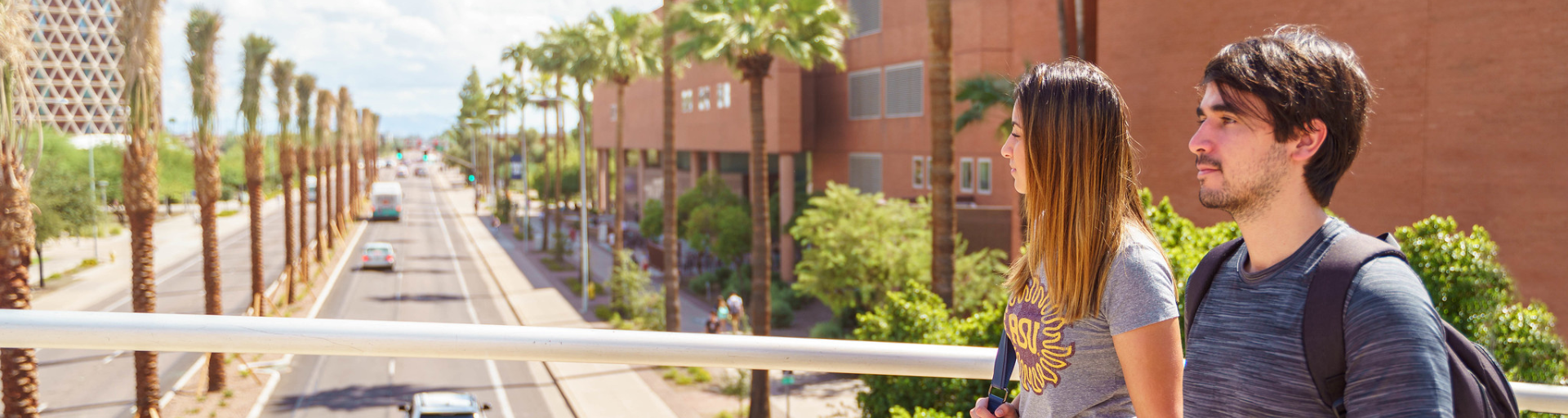 Two students walk over a bridge on the ASU Tempe campus.