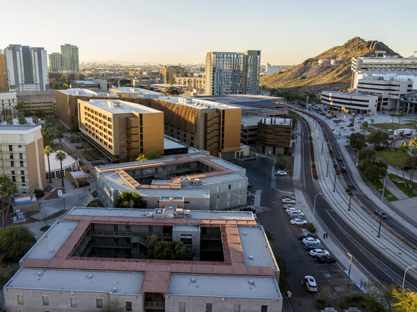Aerial view of modern buildings and a curving road in Tempe, Arizona with a hill featuring a large, white "A" in the background.