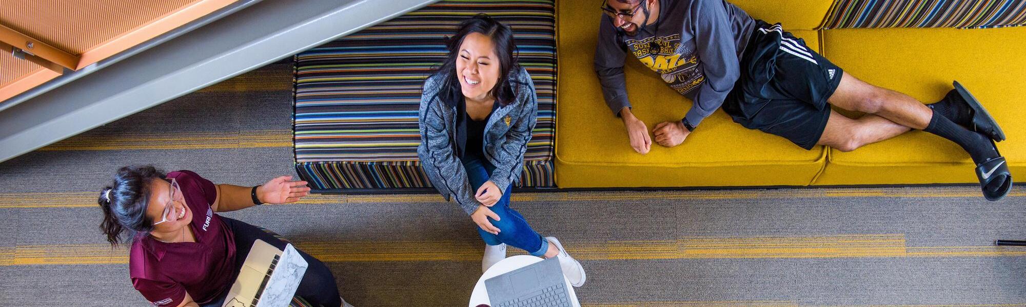 Four ASU students relax in a lounge, happy and talking.
